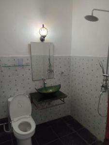 uma casa de banho com um lavatório, um WC e um espelho. em sama sama villa em Midang