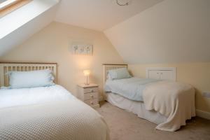 Little Owl Barn في Upton Snodsbury: سريرين في غرفة مع علية