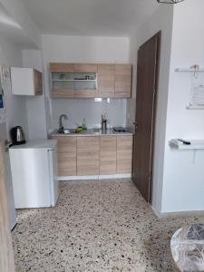 - une cuisine avec des placards en bois et un évier dans l'établissement Explore Greece from Cozy City Centre Apartment, à Chalcis