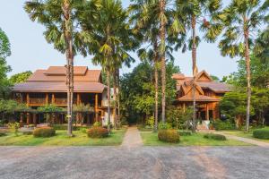 來興的住宿－Vanasin Residence，前面有棕榈树的房子