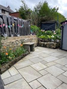 a garden with a bench and a fence and flowers at Penchwintan in Bangor