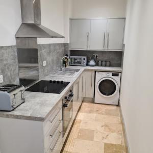a kitchen with a sink and a washing machine at Cozy apartment in Burton town centre in Burton upon Trent
