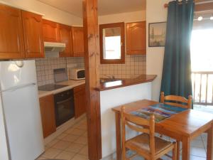 cocina con armarios de madera, mesa, mesa y sillas en Entre lac et montagnes, en Savines