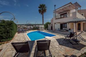 a villa with a swimming pool in front of a house at Villa Emma in Gerani