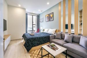 ein Wohnzimmer mit einer Couch und einem Bett darin in der Unterkunft Summerset Saigon - The Perfect Place to Live in District 1 in Ho-Chi-Minh-Stadt