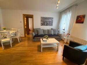 sala de estar con sofá y mesa en Apartamentos Alfonso XIII en La Granja de San Ildefonso