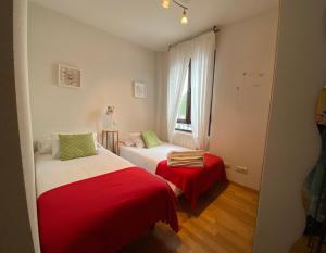 a bedroom with two beds and a window at Apartamentos Alfonso XIII in La Granja de San Ildefonso