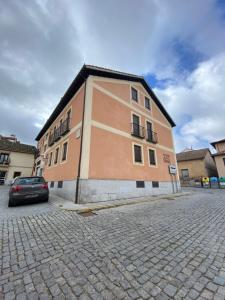 ラ・グランハ・デ・サン・イルデフォンソにあるApartamentos Alfonso XIIIの建物の前に車が駐車されている