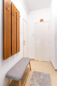 Habitación con banco y pared blanca en Central Studio Apartment, en Székesfehérvár