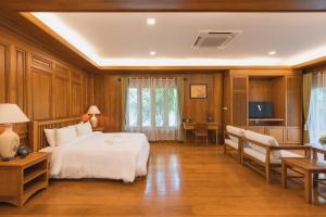 Dormitorio con cama, escritorio y TV en Vanasin Residence, en Tak