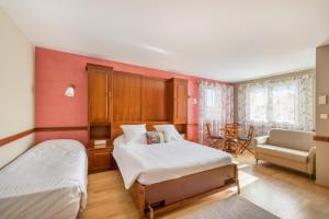 - une chambre avec deux lits, une chaise et un canapé dans l'établissement Hôtel Newport, à Villefranche-sur-Saône