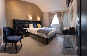 um quarto com uma cama king-size e uma cadeira em Woodenbridge Hotel em Arklow