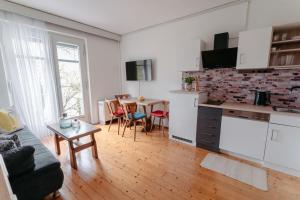 a living room with a kitchen and a table with chairs at Apartments Obir am Wörthersee in Krumpendorf am Wörthersee