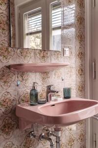 a bathroom with a pink sink and a mirror at Apartments Obir am Wörthersee in Krumpendorf am Wörthersee
