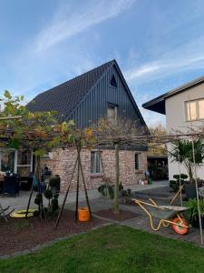 una casa con techo negro y parque infantil en Ferienhaus im Grünen 