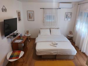 una piccola camera con letto e televisore di Ljubovic apartman a Podgorica