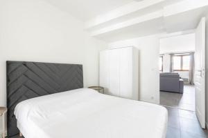 - une chambre blanche avec un lit et un canapé dans l'établissement Agréable appartement prés de Paris - II, aux Lilas