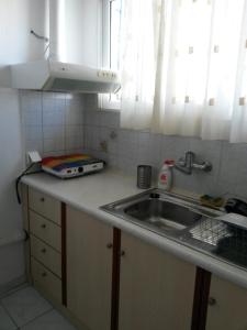 a kitchen counter with a sink and a window at Drakopanagiotaki Rooms in Agios Andreas