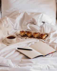 - une assiette de nourriture et une tasse de café sur le lit dans l'établissement OLF Hotel, à Baku