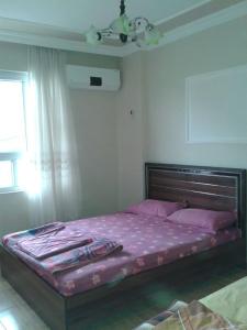 a bedroom with a large bed with purple sheets at Nemrut Dağı Işik Pansi̇on in Karadut