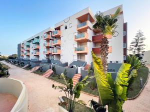 um grande edifício de apartamentos com plantas em frente em Apartamentos Moon Dreams Almerimar em Almerimar