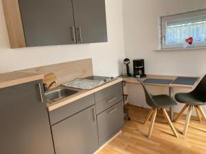 una pequeña cocina con fregadero y escritorio en Ingrid Merkle aus Neckarsulm en Karby