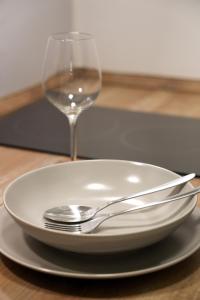 a plate with a fork and a glass of wine at JAWO Apartments Koblenz modern & zentral in Koblenz