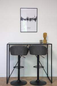 a glass desk with two chairs in front of a wall at JAWO Apartments Koblenz modern & zentral in Koblenz