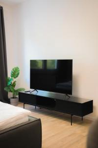 a flat screen tv sitting on a black entertainment center at JAWO Apartments Koblenz modern & zentral in Koblenz