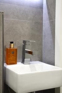 un lavandino bianco con dispenser di sapone in bagno di JAWO Apartments Koblenz modern & zentral a Coblenza