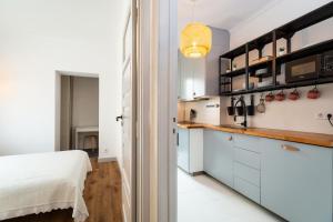 kuchnia z białymi szafkami i łóżko w pokoju w obiekcie Minimalist Apartment In Caldas w mieście Caldas da Rainha