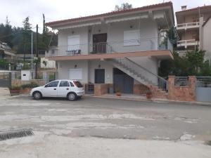un coche blanco estacionado frente a un edificio en Vagelis Nemea apartments, en Neméa