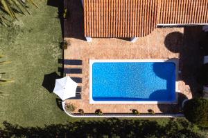 einen Blick über einen Pool mit Sonnenschirm in der Unterkunft Casa Luzerna in Carvoeiro