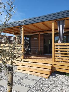 a home with a wooden deck and a house at Mobile Homes Karlo & Dino in Pula