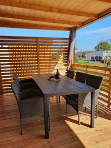 a wooden table and chairs on a wooden deck at Mobile Homes Karlo & Dino in Pula +29 photos
