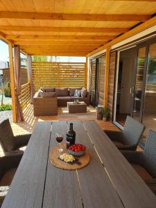 - une table en bois avec un verre de vin sur la terrasse dans l'établissement Mobile Homes Karlo & Dino, à Pula
