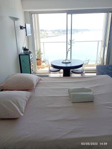 a bedroom with a white bed with a table and a window at AGTBAB in Biarritz