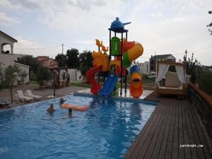a family playing in a swimming pool with a playground at Mobile Homes Karlo & Dino in Pula