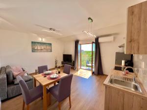 een keuken en woonkamer met een tafel en een bank bij Apartmani Marijana & Iva in Jadranovo