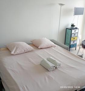 Una cama blanca con dos almohadas encima. en AGTBAB, en Biarritz