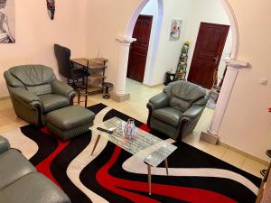 una sala de estar con sillas y una mesa sobre una alfombra. en The Palace, en Douala