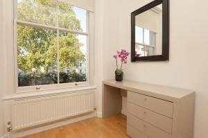 een kaptafel met een spiegel en een raam bij Concept Serviced Apartments by Concept Apartments in Londen