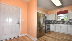 cocina con paredes de color naranja y nevera en 531 River Crossing Home, en North Myrtle Beach