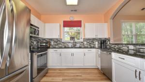 cocina con armarios blancos y nevera de acero inoxidable en 531 River Crossing Home, en North Myrtle Beach