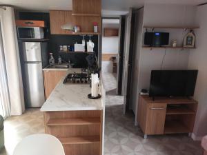 a kitchen with a stove and a tv in it at MOBIL HOME LE BIENVENUE 3 CH VALRAS PLAGE in Valras-Plage