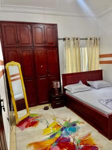 een slaapkamer met een bed en een spiegel op de vloer bij The Palace in Douala