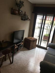 een woonkamer met een flatscreen-tv en een tafel bij Apartamento en el centro de asturias in Langreo
