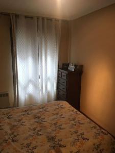 een slaapkamer met een bed, een dressoir en een raam bij Apartamento en el centro de asturias in Langreo