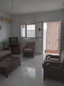 sala de estar con 2 sofás y TV en Confortable Maisonnette prés de la plage à Dar el Alouch, en Kelibia
