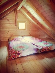 een bed in een houten zolderkamer bij Lesena hiška čebelnjak in Loče pri Poljčanah